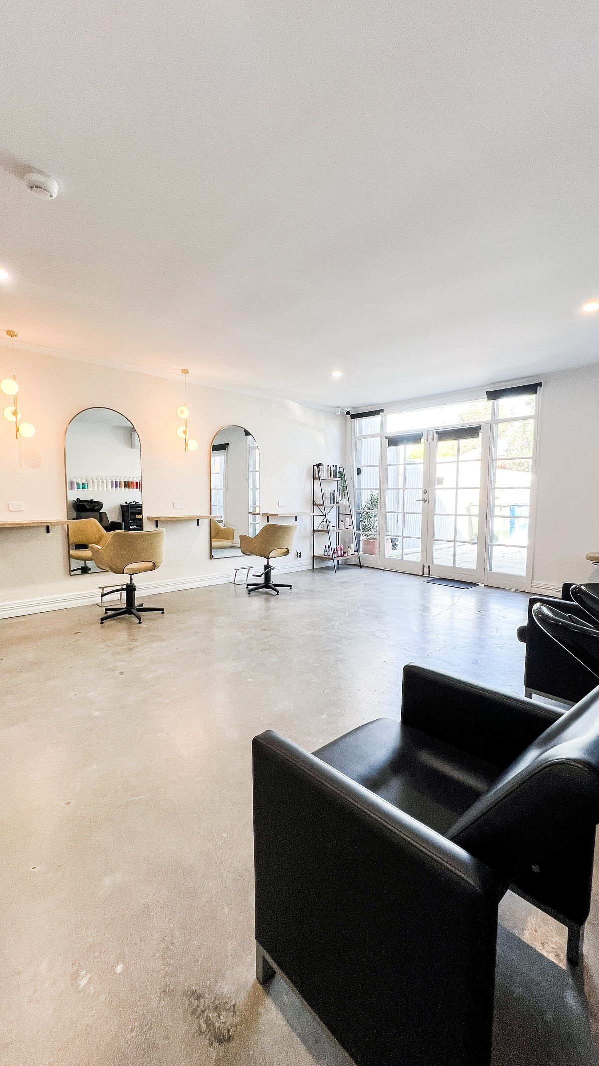 The Sugarcoat Studios chair hire space, with styling stations, arched mirrors and natural light from the front doors